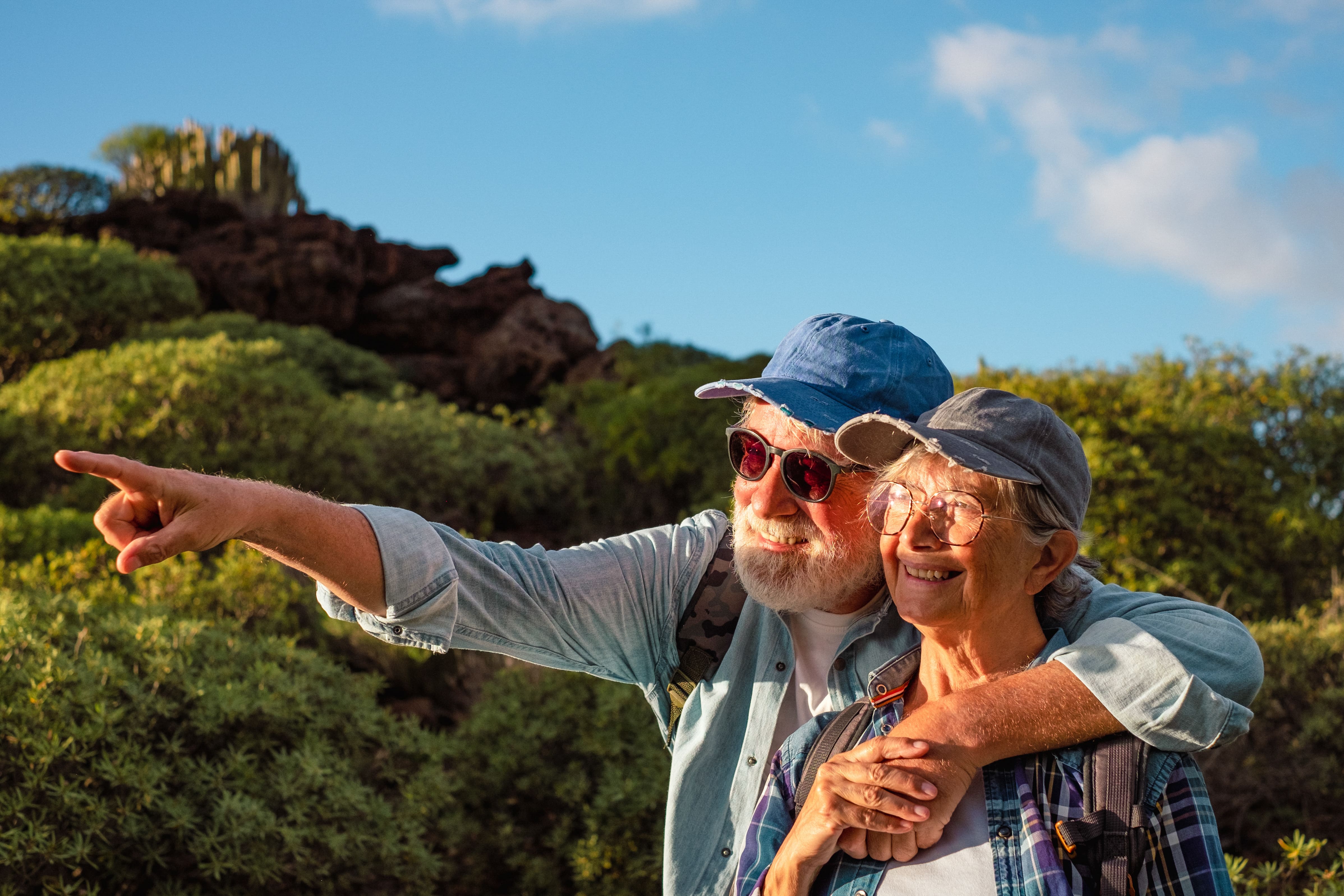 couple de retraités souriant en vacances observant le couché de soleil
